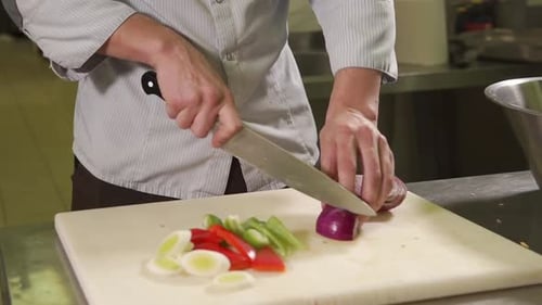Close Up Shot of the Chef's Hand, He Cuts, and Then Breaks the Red Onion in Half