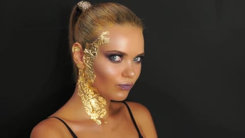 Fashion Model Standing Against the Black Wall and Striking a Pose for Studio Fashion Photo Shoot