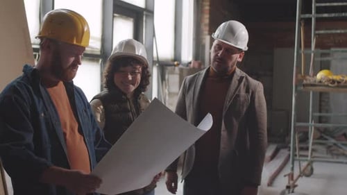 Construction Workers Reviewing Blueprint on Site