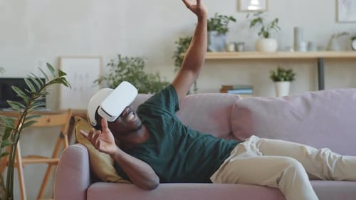 Man Experiencing Virtual Reality on Couch at Home