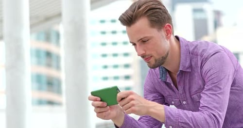 Young Adult Man Uses Cell Phone in City