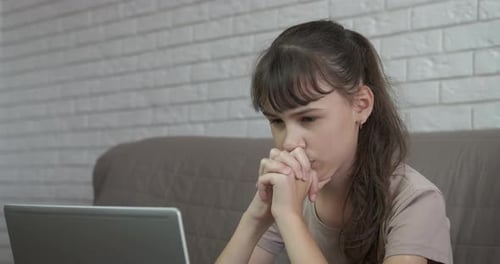 Girl reading bad news online.