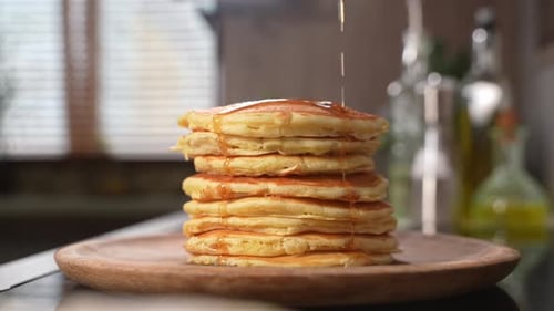 Syrupy Pancakes Stacked High on Wooden Plate