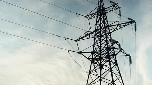 Transmission Tower Against Sky with Wispy Clouds