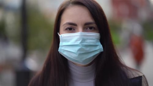 Portrait of a Mixed Race Woman in the City Streets During the Day, Wearing a Face Mask Against the