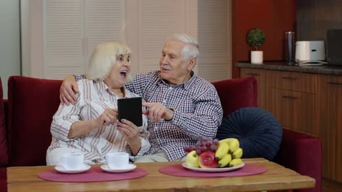 Senior Couple Relaxing Using Tablet at Home