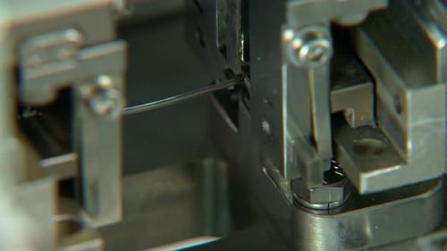 Close up on industrial production line for small parts, robotic arms