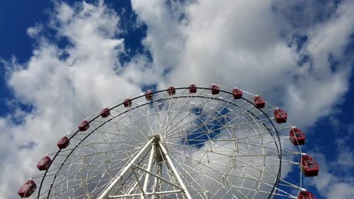 Time Lapse of Large Ferris Wheel Spinning Around on a Bright Sunny Day with Clouds Moving