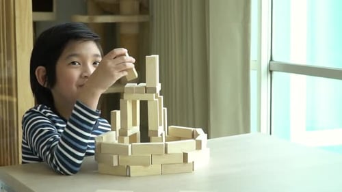 Cute Asian Child Playing Wooden Bolck In The Living Room