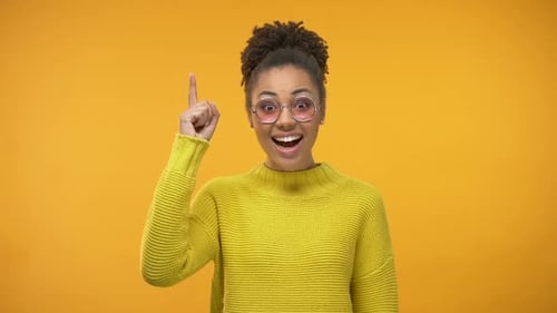 Young Woman Having Idea on Yellow Background