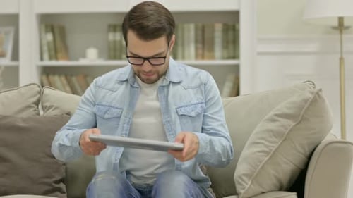 Young Man Using Laptop on Sofa Indoors