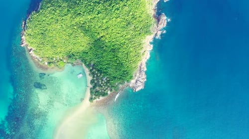 Aerial - uninhabited island with palm trees in the aquamarine calm sea water. high angle in Koh Pha