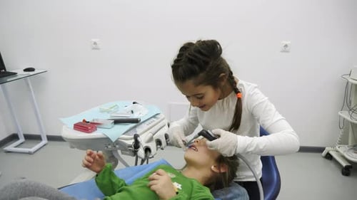 Child Dentist Working on Patient in Dental Office