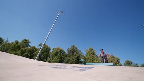Man Does Bike Trick at Skate Park