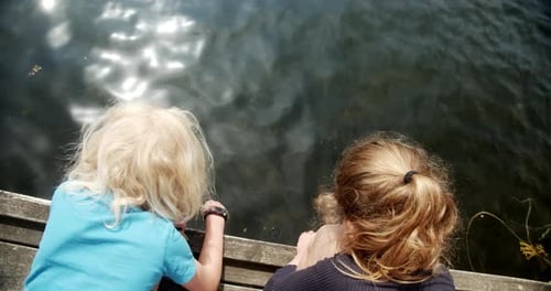 Kinder warten geduldig auf ihren Fang, als sie eine Schnur ins Wasser geworfen haben
