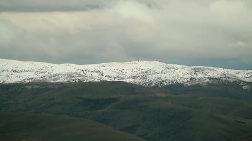 Snow-Capped Mountains with Rolling Hills Landscape