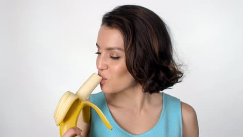 Young Adult Woman Eating a Banana Smiling