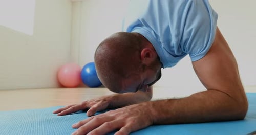 Man exercising on mat in the fitness studio 4k