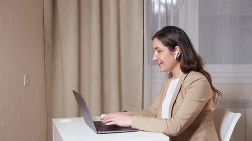 Copywriter in Headphones Talks on Video Call and Types