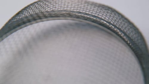 Macro Shot of Silver Sieve on White Surface