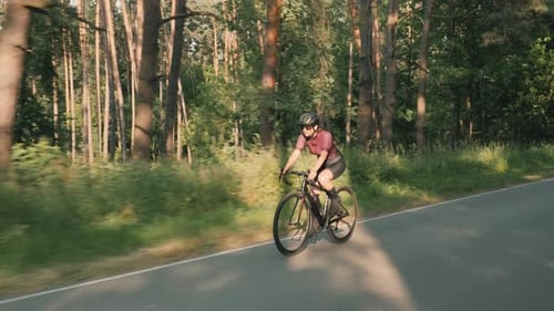 Radfahrende Frau. Sportlerin beim Fahrradfahren im Waldpark. Motivation beim Radsport