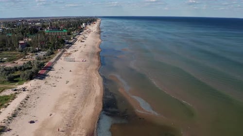 Beautiful flight in summer over the beach. People are resting near the sea.