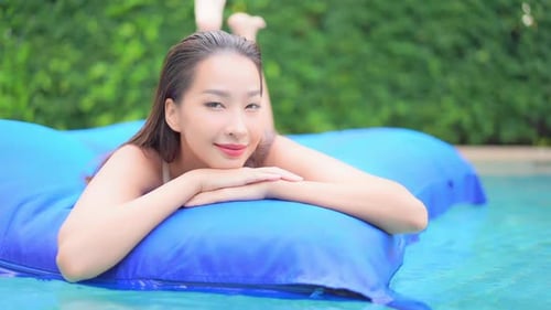 Portrait of Beautiful Sexy Exotic Woman on Air Mattress in Swimming Pool on Tropical Holiday, Looki