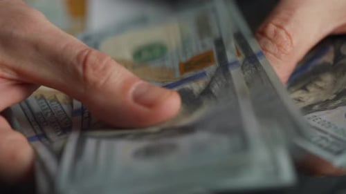 Hands Counting US Dollar Bills or Paying in Cash