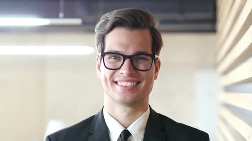 Man Smiling Wearing Glasses and Suit in Office