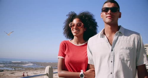 Couple walking together on beach promenade in the sunshine