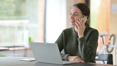 Woman Talking on Cell Phone in Home Office