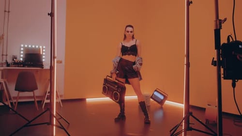 Stylish Woman Posing with Boombox in Studio