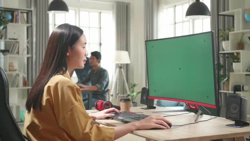 Asian Female Works With Mock Up Green Screen Computer Display In Office