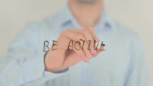 Man Writes 'Be Active' on Clear Surface