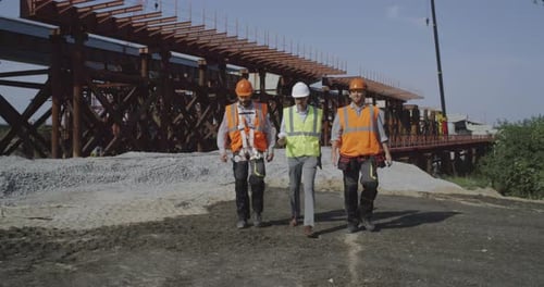 Professional Engineers Walking Towards Unfinished Bridge