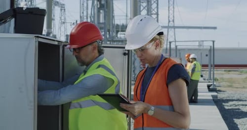 Engineers Checking Transformer Box on Power Plant