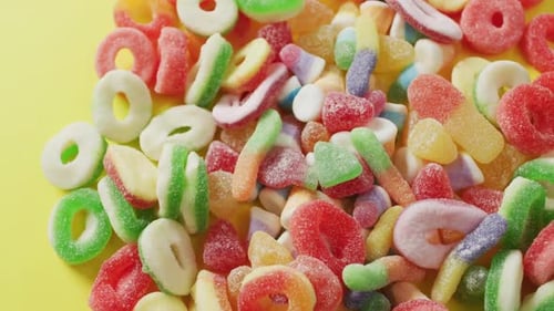 Video of colourful jelly candy on yellow background