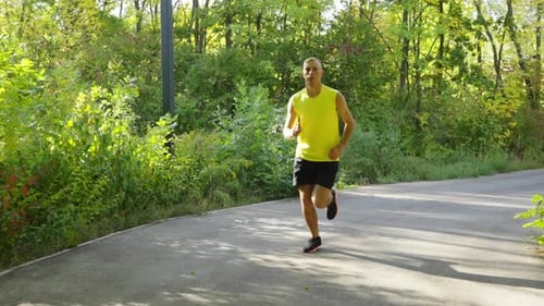 Man Jogging on Path Through Urban Park