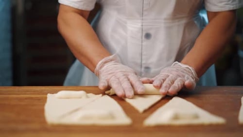 Femme faisant un croissant à partir de pâte dans la cuisine