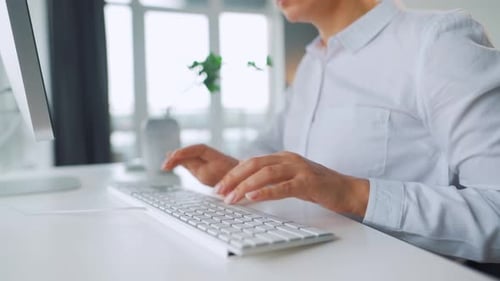 Woman Typing on Computer Keyboard at Desk