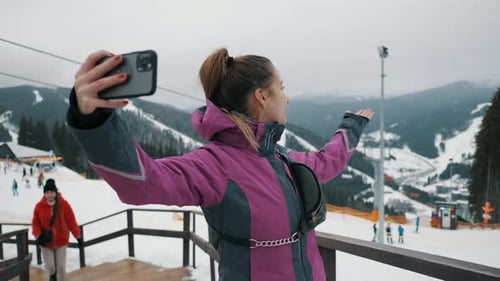 Happy Woman Making Video Calls To Family at Ski Resort in Mountains Selfie in Winter Mountains