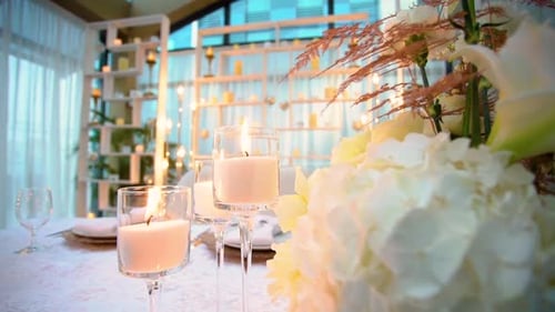 Close-up View of Burning Candles in Transparent Glasses Standing on Banquet Table of Wedding Feast
