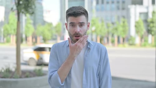 Young Adult Man Expressing Surprise in Urban Setting