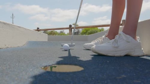 Close Up of the Golf Stick Hitting a Golf Ball Mini Golf