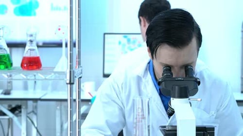 Scientist looking through microscope
