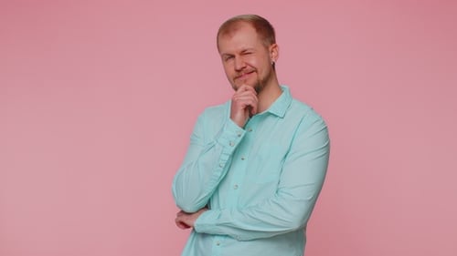 Lächelnder verspielter glücklicher Mann blinkendes Auge, der in die Kamera schaut, mit einem zackigen Lächeln,