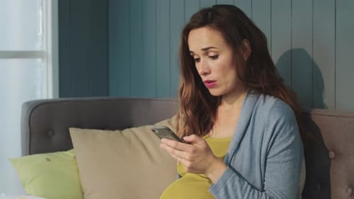 Pregnant Woman Using Smartphone at Home