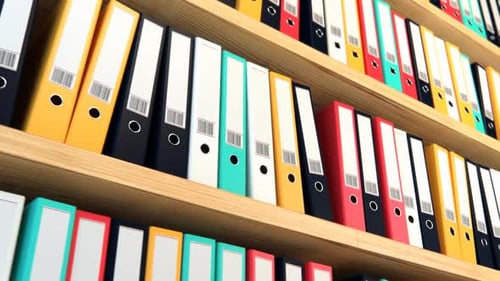 Close up on the row of the file colorful binders stacked on the wooden shelf.