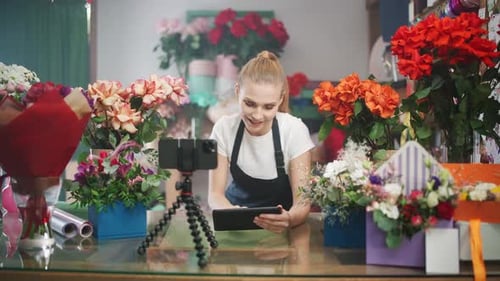 Young Adult Woman Filming Flowers in Shop