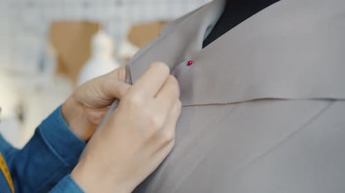 Closeup of Female Hands Sewing New Fashionable Clothing on Tailor's Dummy in Workshop